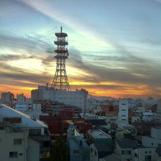 A radio tower above a Japanese cityscape